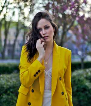 Model in brightyellow woolen coat with dark buttons