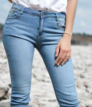 Model in plain yet tight lightblue denim pants